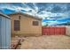 View of the home's backyard featuring gravel ground, a tool shed, and red wooden fence at 17841 N 20Th St, Phoenix, AZ 85022