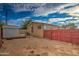 View of the home's backyard with gravel ground, a tool shed, and a red fence at 17841 N 20Th St, Phoenix, AZ 85022