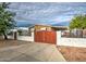 The front yard has a red metal gate and a white brick fence surrounding the property at 17841 N 20Th St, Phoenix, AZ 85022