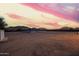 Spacious backyard at sunset with neutral colored land and an open gazebo at 1819 W Joy Ranch Rd, Phoenix, AZ 85086