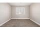 Cozy bedroom featuring neutral carpet, light beige walls, and a window for natural light at 1819 W Joy Ranch Rd, Phoenix, AZ 85086