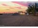 An exterior elevation of a home, accented by a picturesque sunset and ample, natural desert landscaping at 1819 W Joy Ranch Rd, Phoenix, AZ 85086