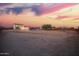 Exterior view showcasing the spacious property, gazebo, and the desert landscape, enhanced by the dramatic sunset at 1819 W Joy Ranch Rd, Phoenix, AZ 85086