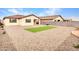 Desert backyard showing the house and artificial turf framed with gravel and foliage at 18445 W Pasadena Ave, Litchfield Park, AZ 85340