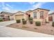 Inviting home with a neutral-colored exterior, tidy landscaping, and a spacious driveway at 18445 W Pasadena Ave, Litchfield Park, AZ 85340