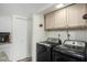 Bright laundry room with modern washer and dryer set and overhead storage at 1920 W Lindner W Ave # 277, Mesa, AZ 85202