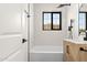 Bathroom with tiled walls, tub, shower, and a stylish wood-grain vanity with a black faucet at 2601 E Willetta St, Phoenix, AZ 85008