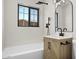 Modern bathroom with a tiled shower, wood vanity, sleek mirror, and contemporary fixtures at 2601 E Willetta St, Phoenix, AZ 85008