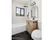 Chic bathroom with a modern vanity, black hexagon tile floor, stylish fixtures, and a tiled shower at 2601 E Willetta St, Phoenix, AZ 85008