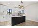 Modern kitchen featuring white cabinetry, black kitchen island, stainless-steel appliances, and modern light fixture at 2601 E Willetta St, Phoenix, AZ 85008