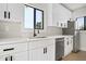 Well-lit kitchen with white cabinets, stainless steel appliances, and a modern faucet with contrasting hardware at 2601 E Willetta St, Phoenix, AZ 85008
