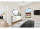 Bright bedroom featuring neutral tones, modern dresser, large window, and a glimpse of the living area at 2601 E Willetta St, Phoenix, AZ 85008