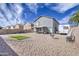 Backyard featuring a gravel landscape, covered patio and gray two story house at 2607 W Ironstone Ave, Apache Junction, AZ 85120