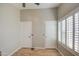 This bedroom features wood floors, two white doors, and a window with shutters at 2607 W Ironstone Ave, Apache Junction, AZ 85120