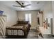 This cozy bedroom features a ceiling fan, wood floors, shutters, and a bed at 2607 W Ironstone Ave, Apache Junction, AZ 85120