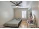 This cozy bedroom features a ceiling fan, wood floors, a window with shutters, and a sliding-door closet at 2607 W Ironstone Ave, Apache Junction, AZ 85120