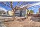 Well-maintained front yard with desert landscaping, mature trees, and a charming two-story gray stucco home at 2607 W Ironstone Ave, Apache Junction, AZ 85120