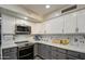 Charming kitchen features modern appliances, white upper cabinets, and gray lower cabinets at 2607 W Ironstone Ave, Apache Junction, AZ 85120