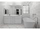 Bathroom featuring a modern soaking tub, double vanity with marble counters, and a stylish chandelier at 280 W Wisteria Pl, Chandler, AZ 85248