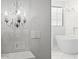 Bathroom featuring a modern soaking tub with decorative chandelier and white marble tile at 280 W Wisteria Pl, Chandler, AZ 85248