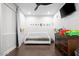 Bright bedroom with a white daybed, dark wood floors, ceiling fan, and playful wall decor at 280 W Wisteria Pl, Chandler, AZ 85248