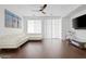 Spacious living room with a large white sofa, modern ceiling fan, and rich hardwood floors at 280 W Wisteria Pl, Chandler, AZ 85248