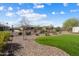 Landscaped backyard with artificial turf, desert plants, and a wrought iron fence at 3074 N 167Th Dr, Goodyear, AZ 85395