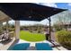 Inviting backyard patio with an umbrella, lounge chairs, and well-manicured artificial grass at 3074 N 167Th Dr, Goodyear, AZ 85395