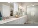 Clean bathroom with double vanity, tile backsplash, and a glass-enclosed shower at 3074 N 167Th Dr, Goodyear, AZ 85395