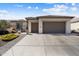 Inviting home exterior with three-car garage, lush front yard landscape, and inviting curb appeal at 3074 N 167Th Dr, Goodyear, AZ 85395