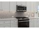 Close-up view of kitchen appliances and backsplash at 3074 N 167Th Dr, Goodyear, AZ 85395