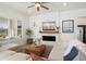 Cozy living room featuring a fireplace, ceiling fan, and natural light from shuttered windows at 3074 N 167Th Dr, Goodyear, AZ 85395