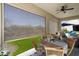 Covered outdoor patio with a ceiling fan, dining area, and comfortable lounge seating at 3074 N 167Th Dr, Goodyear, AZ 85395