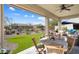 Covered outdoor patio featuring a dining table, seating area, and views of the landscaped backyard at 3074 N 167Th Dr, Goodyear, AZ 85395