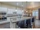 A kitchen island features granite countertops, seating, and modern pendant lighting, adjacent to a dining area at 32742 N 15Th Gln, Phoenix, AZ 85085
