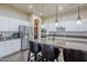 An open kitchen features an island with a sink, white cabinets, stainless steel appliances, and modern accents at 32742 N 15Th Gln, Phoenix, AZ 85085