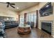 Spacious living room featuring a fireplace, ceiling fan, and access to the backyard at 32742 N 15Th Gln, Phoenix, AZ 85085