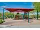 Community playground featuring a shade cover, climbing structure, swings, and seesaw at 32742 N 15Th Gln, Phoenix, AZ 85085