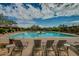 A resort style pool has plenty of seating and is surrounded by desert landscaping and blue skies at 32742 N 15Th Gln, Phoenix, AZ 85085