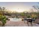 Serene pool area with a waterfall feature, surrounded by lush landscaping and comfortable seating under a shaded pergola at 32742 N 15Th Gln, Phoenix, AZ 85085