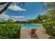 A lounge chair sits next to the resort style pool surrounded by desert landscaping and a blue sky at 32742 N 15Th Gln, Phoenix, AZ 85085