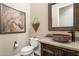 A cozy powder room with decorative horse art, unique vessel sink and mirror, and wood-look vanity at 32742 N 15Th Gln, Phoenix, AZ 85085