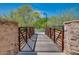 Park walkway featuring a wooden bridge with stone supports and a desert landscape at 32742 N 15Th Gln, Phoenix, AZ 85085