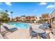 Relaxing community pool area with lounge chairs, tables, and manicured landscaping near contemporary buildings at 3500 N Hayden Rd # 2201, Scottsdale, AZ 85251