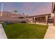 Enjoy this backyard featuring a covered outdoor kitchen with bar seating, hot tub, and green space at 3840 W Brogan Ct, New River, AZ 85087