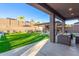 The covered patio provides access to a large backyard with an outdoor kitchen and green grass at 3840 W Brogan Ct, New River, AZ 85087