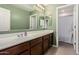 Well-lit bathroom with a large mirror, vanity with cabinet storage, and a tile floor at 3840 W Brogan Ct, New River, AZ 85087