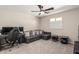 Comfortable bedroom area with a gray sofa, desk setup, ceiling fan, and ample natural light at 3840 W Brogan Ct, New River, AZ 85087