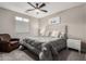 Inviting bedroom featuring soft gray bedding, a ceiling fan, neutral decor and natural light at 3840 W Brogan Ct, New River, AZ 85087