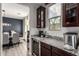 Cozy kitchen featuring granite countertops, built-in beverage cooler, and adjacent dining area at 3840 W Brogan Ct, New River, AZ 85087